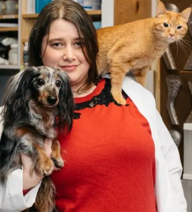 Elizabeth Kost with long-haired dachshund and orange cat